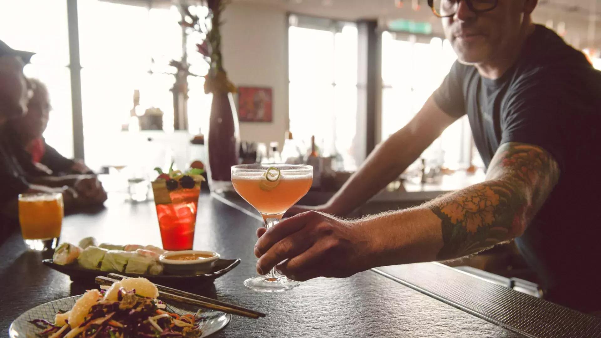 Um barman serve um coquetel a um cliente em um bar em São Francisco.