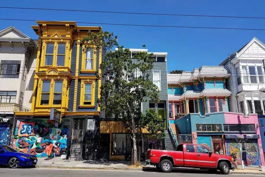 View of colorful buildings on Haight Street with cars parked along the street. San Francisco, California.