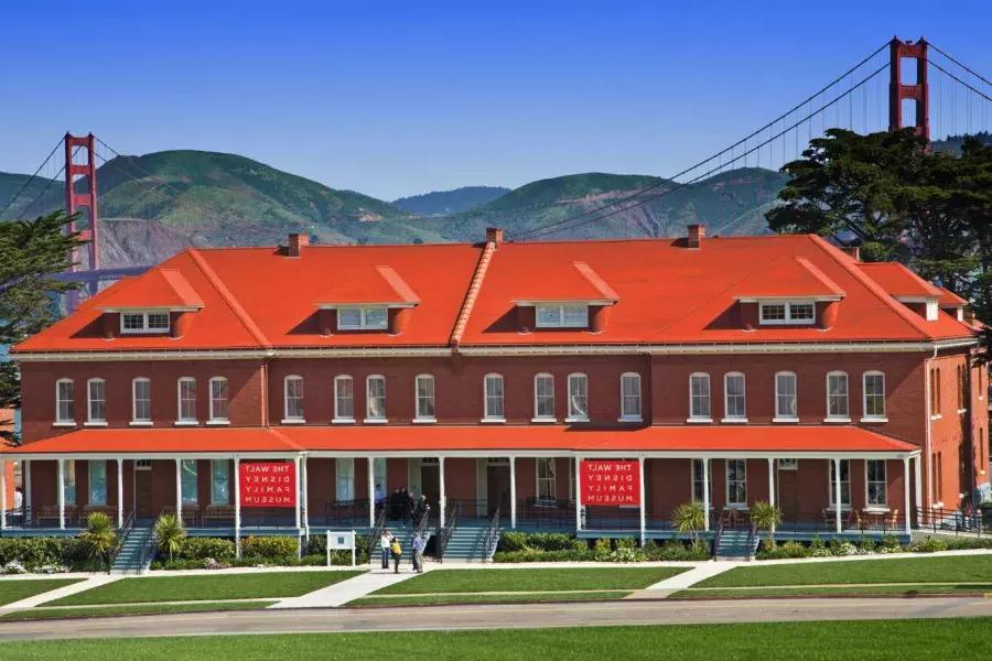The Walt Disney Family Museum, housed in a row of red-brick former barracks, stands in front of the Golden Gate Bridge. San Francisco, California.