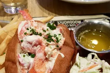 Up-close image of lobster roll with a side of fries