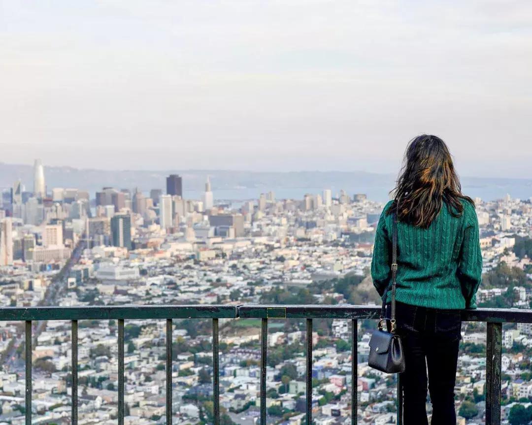 A woman looks at the San Francisco skyline from Twin Peaks.